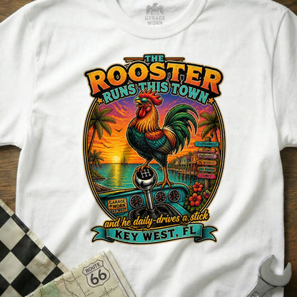 Rooster on a stick shift with Key West sunset and text "The Rooster Runs This Town".