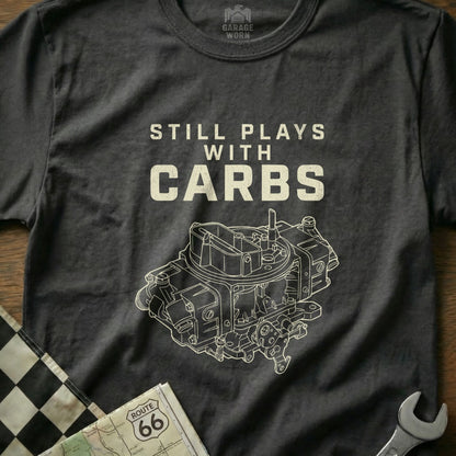 Dark t-shirt with white text "STILL PLAYS WITH CARBS" and carburetor graphic.