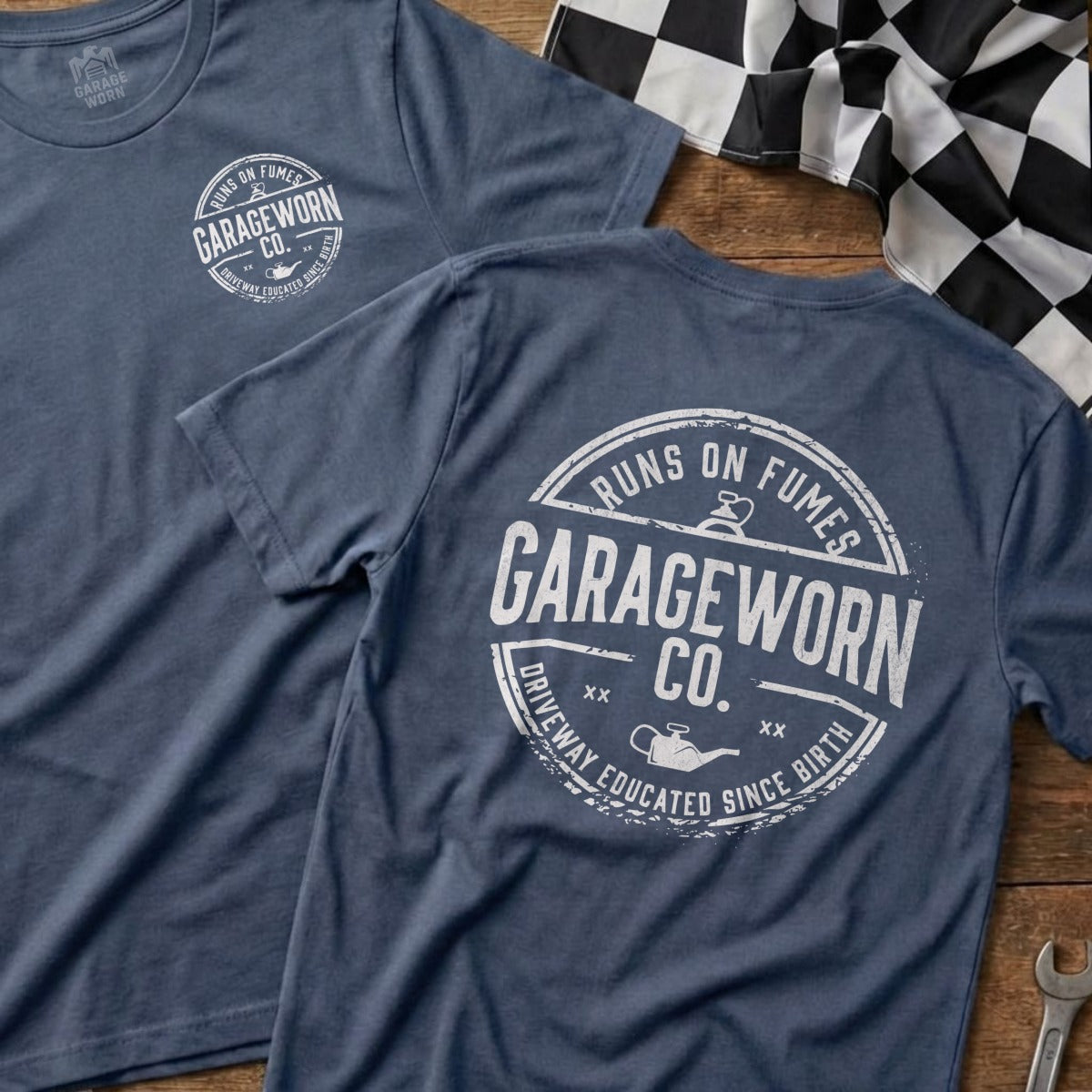 Two navy t-shirts with "Garage Worn Co." logo on a wooden surface.