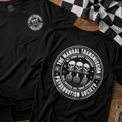Black t-shirt with circular graphic: "The Manual Transmission Preservation Society" with skulls and pedals.