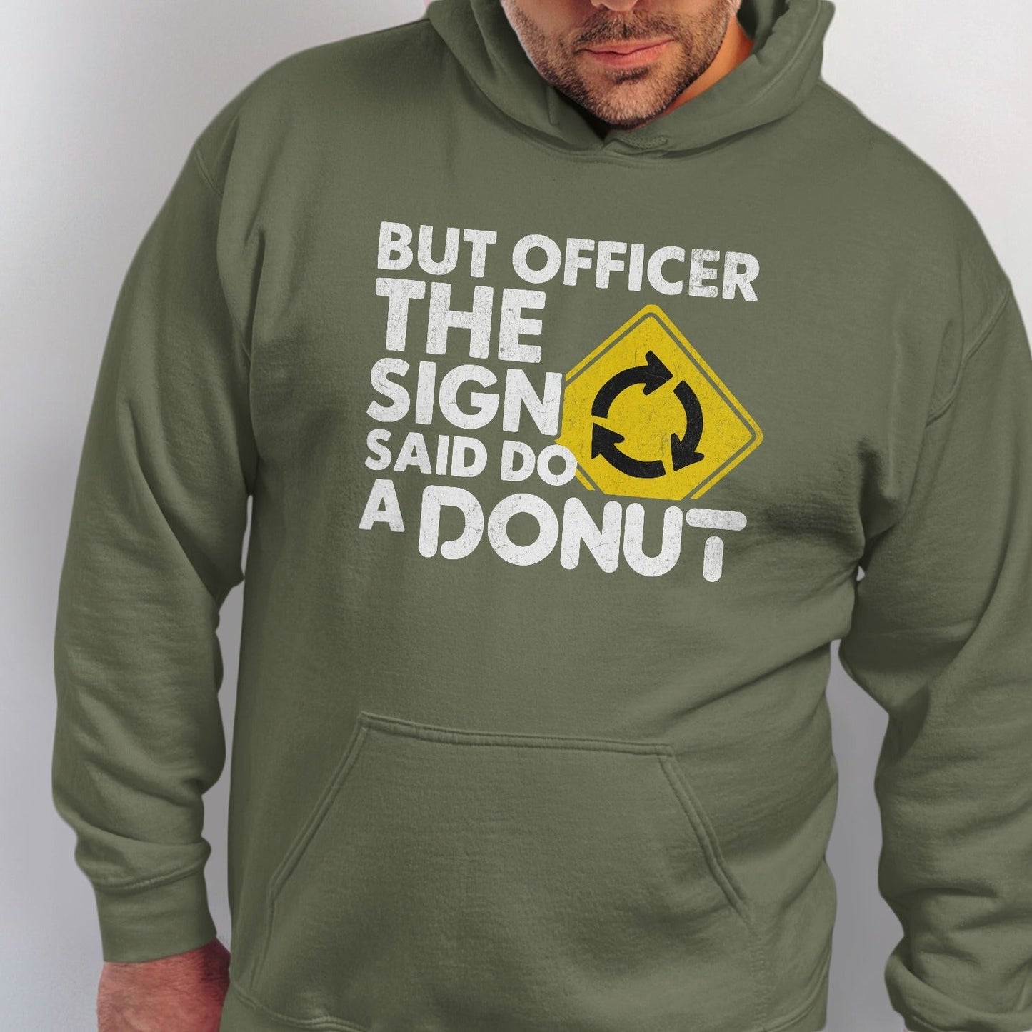 Green hoodie with white text "BUT OFFICER THE SIGN SAID DO A DONUT" and a roundabout sign.