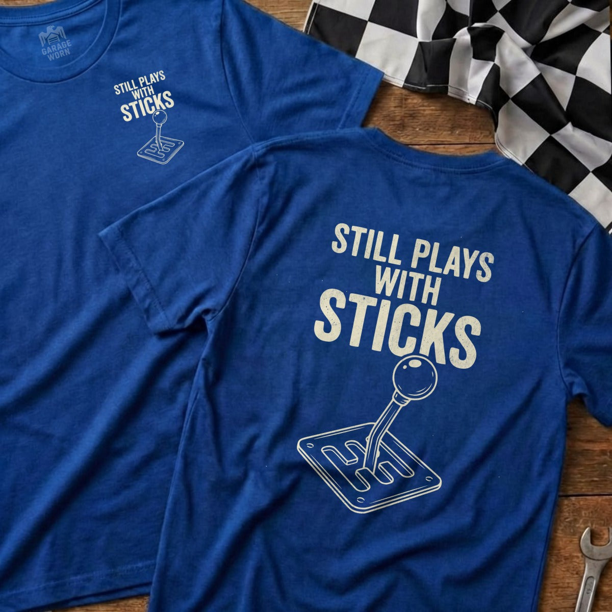 Blue t-shirts with "Still Plays With Sticks" graphic featuring a manual shift knob.