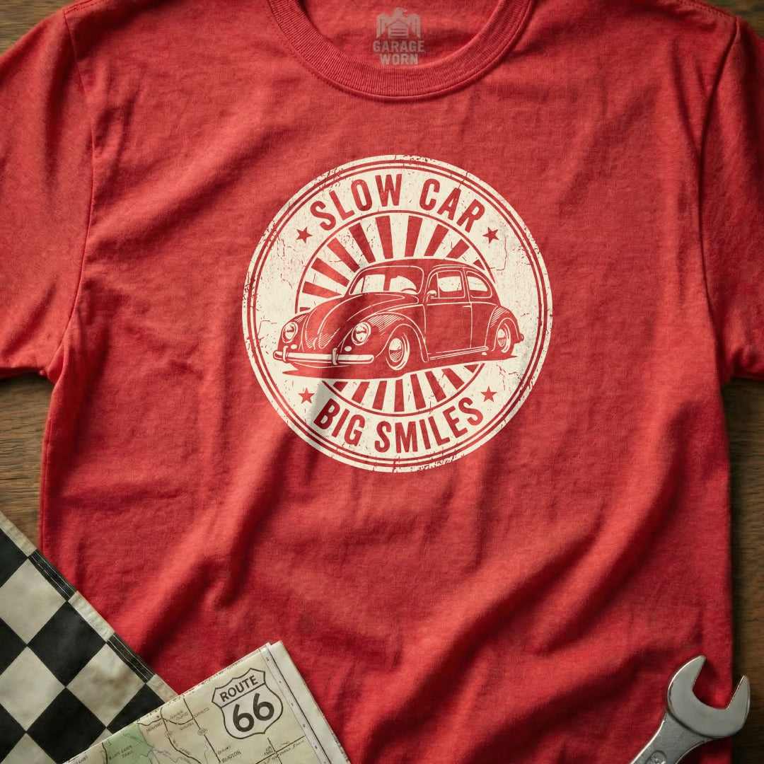 Red t-shirt with graphic of a vintage Volkswagen Beetle and text "Slow Car, Big Smiles".