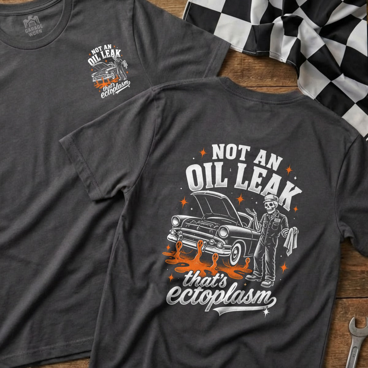 T-shirt with graphic of skeleton mechanic next to a vintage car, "Not an oil leak, that's ectoplasm."