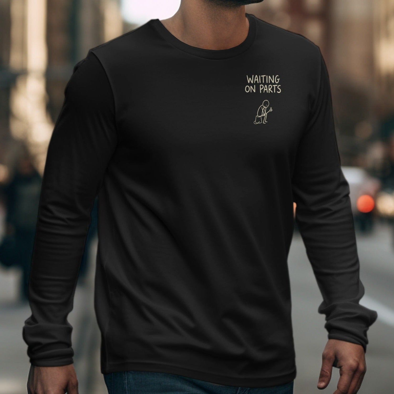 Black long-sleeve shirt with yellow text and a stick figure graphic: "WAITING ON PARTS".
