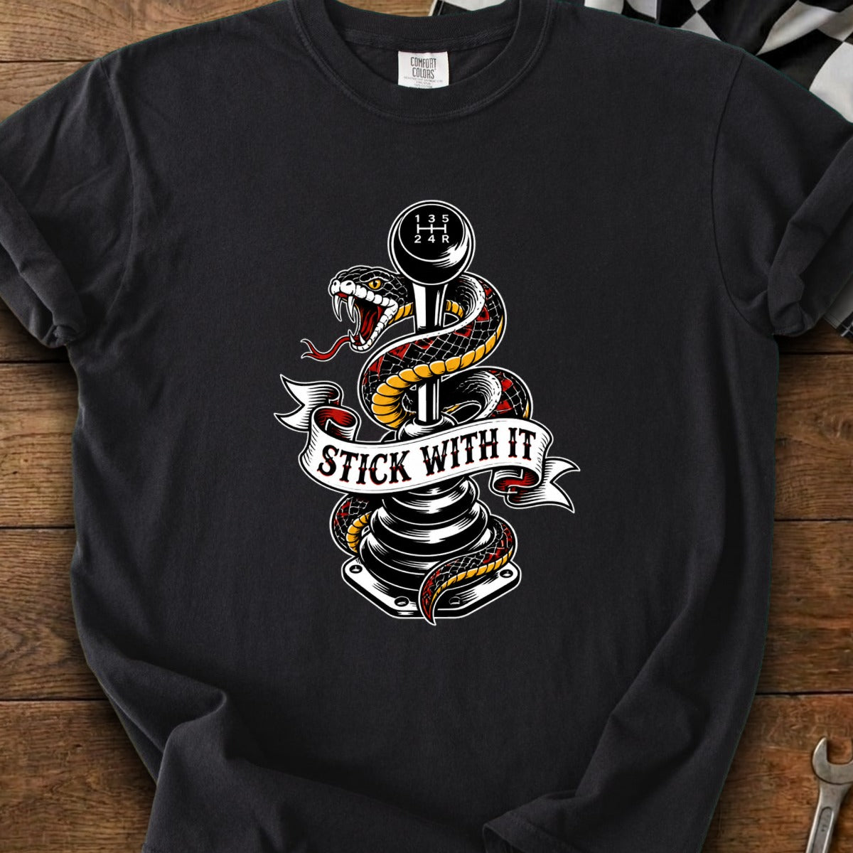 Snake wrapped around gear shift with text "STICK WITH IT" on banner.