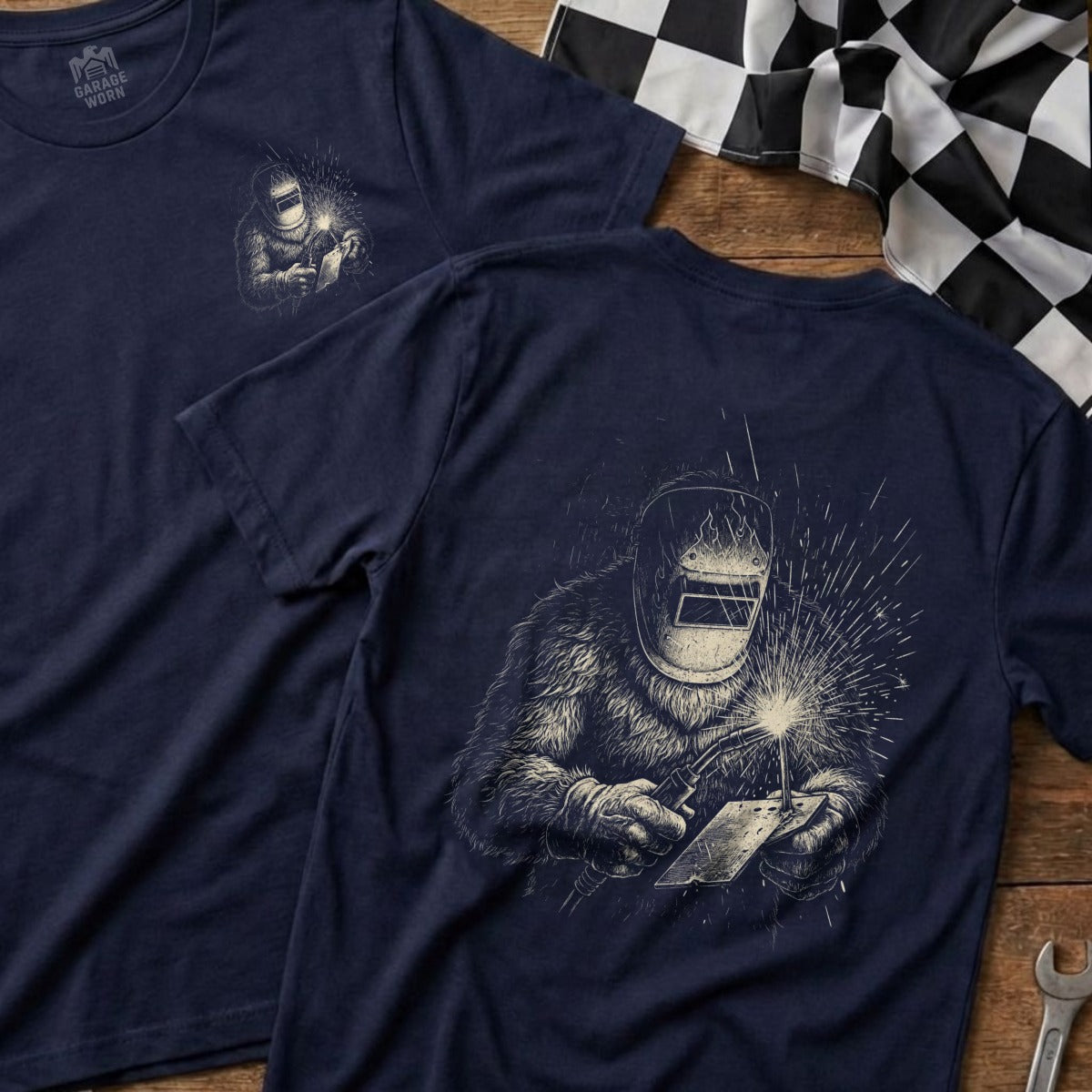 Navy t-shirt with a graphic of a welder with a racing flag background.