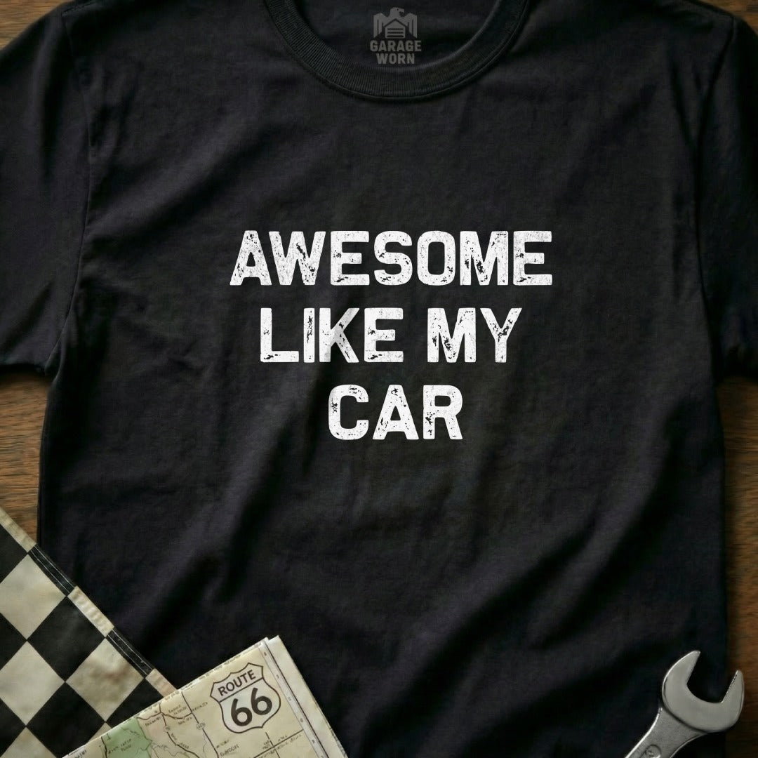Black t-shirt with white text "AWESOME LIKE MY CAR" and checkered flag.