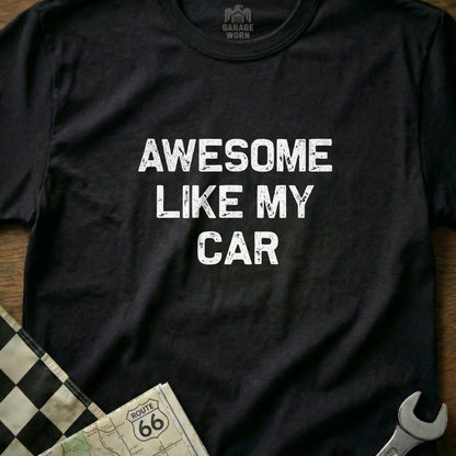 Black t-shirt with white text "AWESOME LIKE MY CAR" and checkered flag.