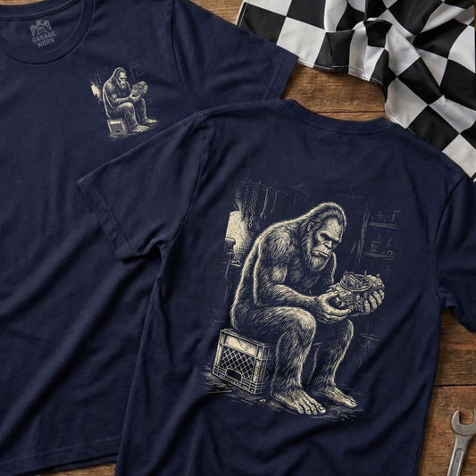 Two navy t-shirts, one with a Bigfoot mechanic graphic, the other plain.
