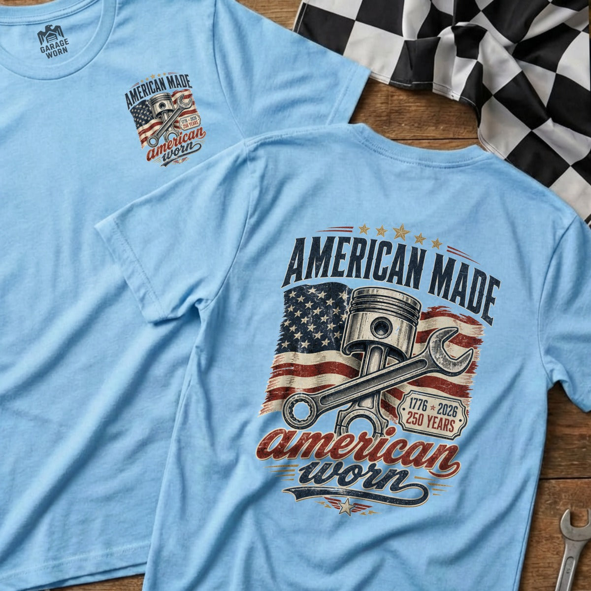 Light blue t-shirt with "American Made" text, piston, wrench, and American flag graphic.
