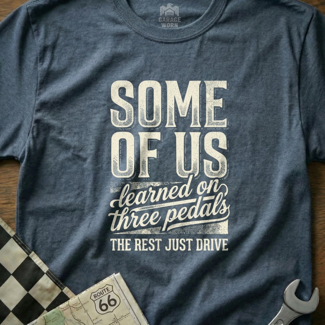 T-shirt with "SOME OF US learned on three pedals THE REST JUST DRIVE" text.