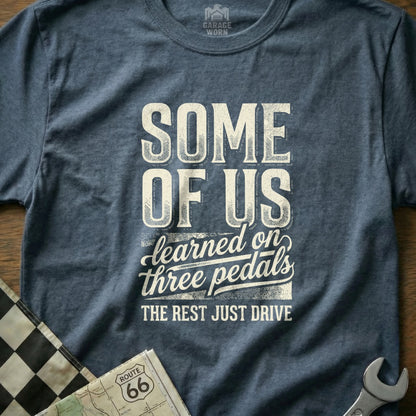 T-shirt with "SOME OF US learned on three pedals THE REST JUST DRIVE" text.