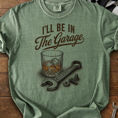 Green t-shirt with "I'll Be In The Garage" graphic, whiskey glass, wrench, and nuts.