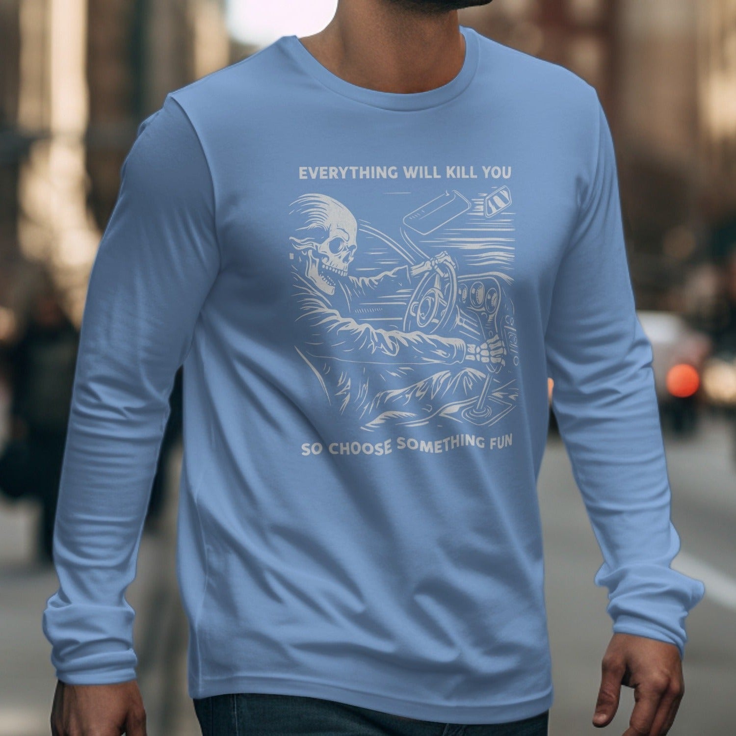 Light blue long-sleeve t-shirt with skeleton driving print and "Everything will kill you so choose something fun" text.