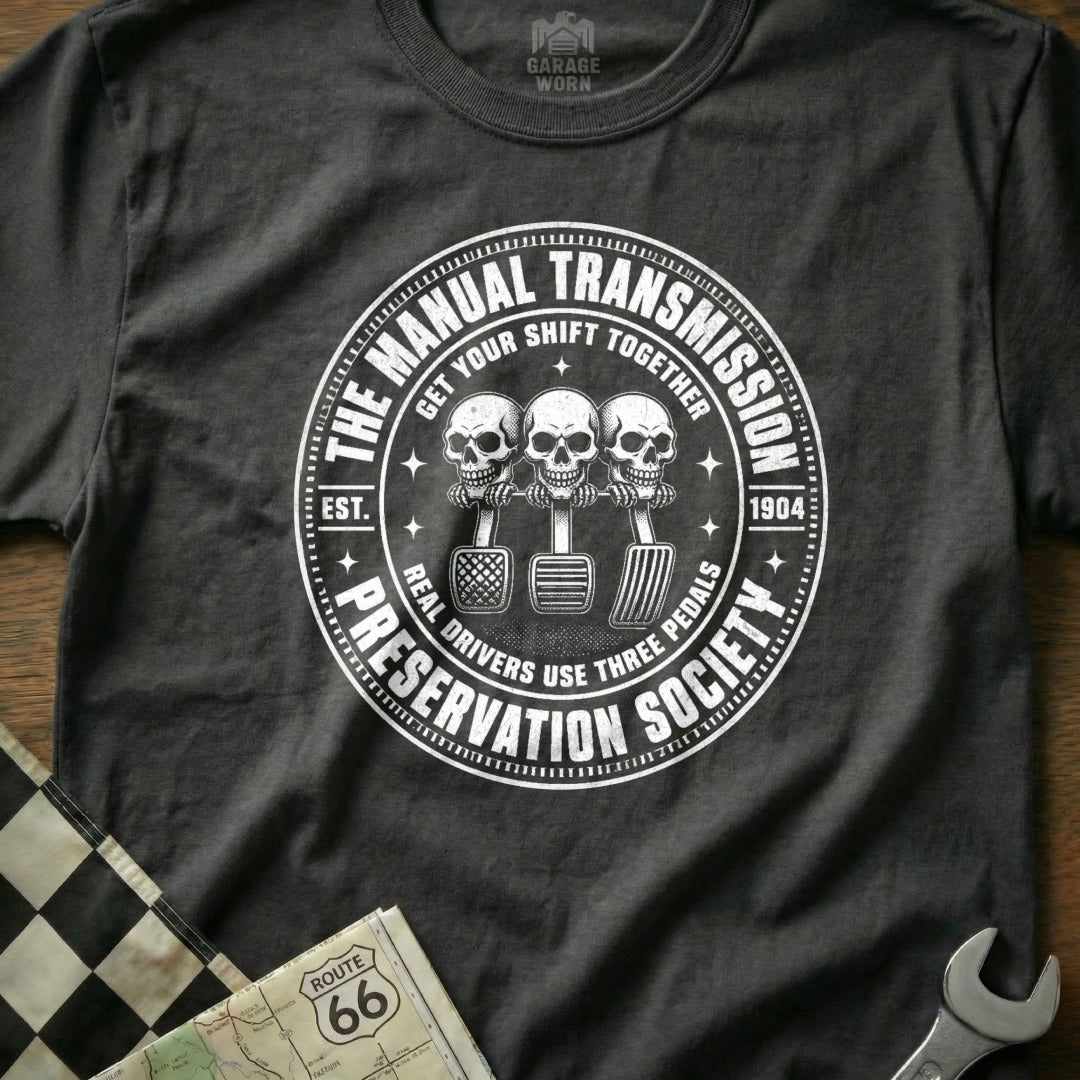 T-shirt with "The Manual Transmission Preservation Society" and skulls operating three pedals.