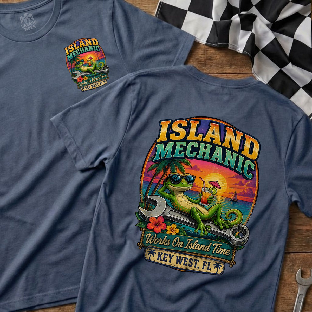 Island Mechanic t-shirt with a gecko relaxing on a wrench, sunset background, and text.