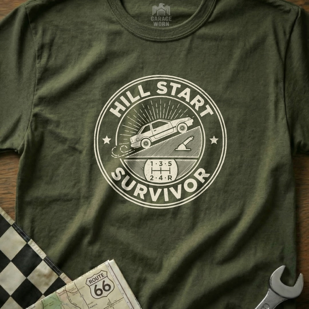 Green t-shirt with white "Hill Start Survivor" graphic and manual transmission gear pattern.
