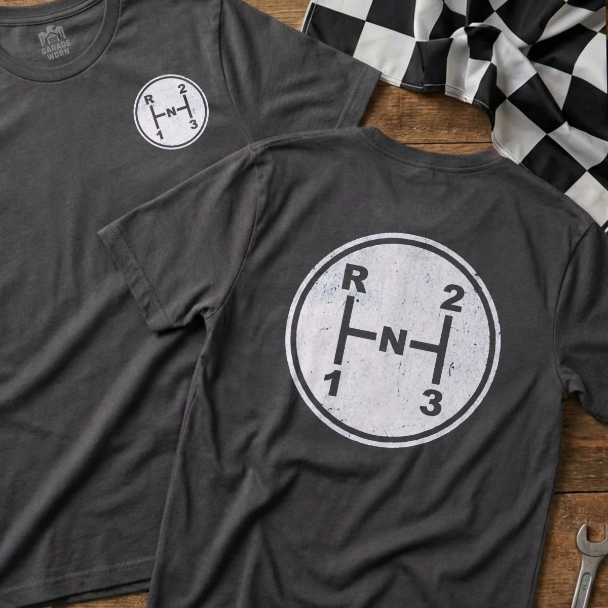 Dark grey t-shirt with a white manual transmission shift pattern graphic.