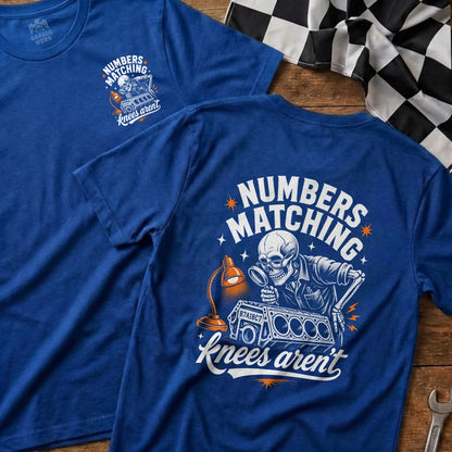 Blue t-shirt with skeleton examining engine part, text "NUMBERS MATCHING knees aren't".