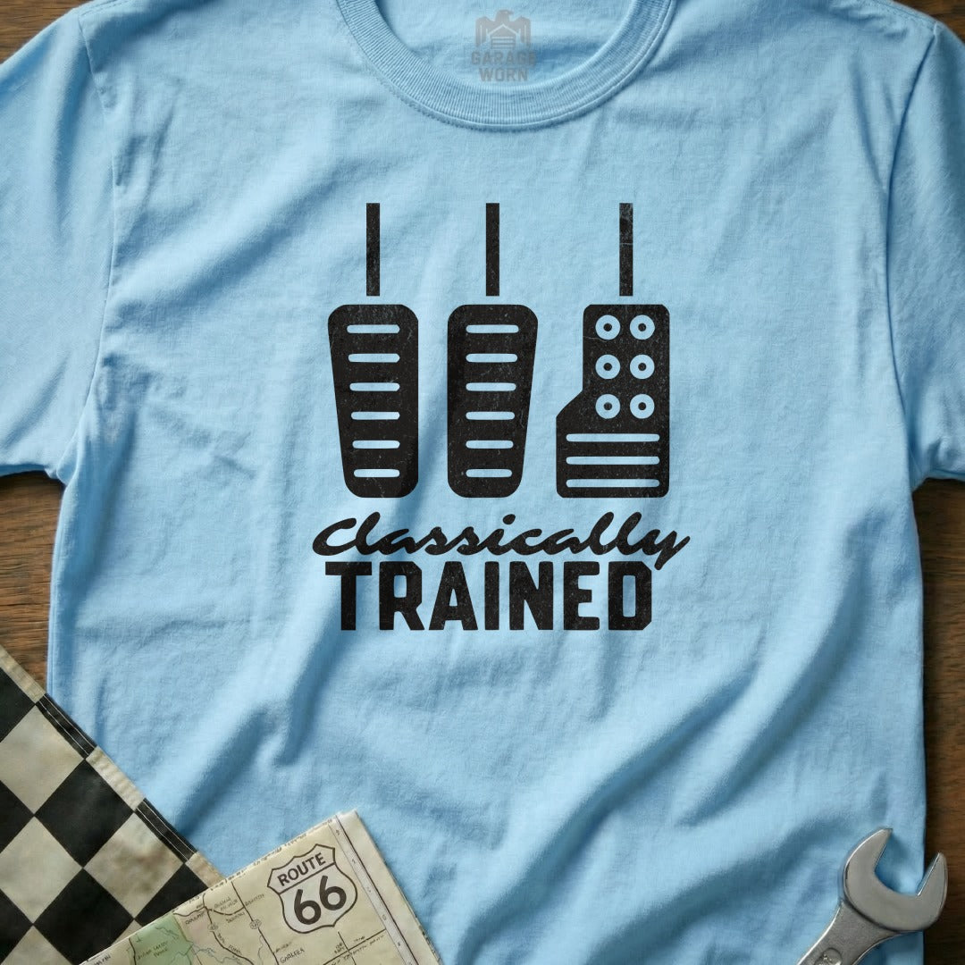 Light blue t-shirt with black graphic of three car pedals and "Classically Trained" text.