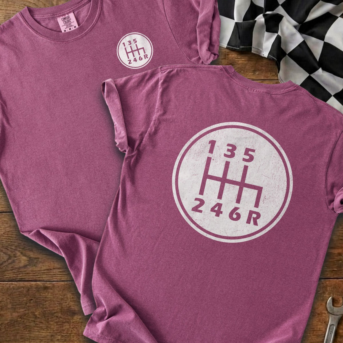 Maroon t-shirt with a white circular graphic of a six-speed manual transmission shift pattern.
