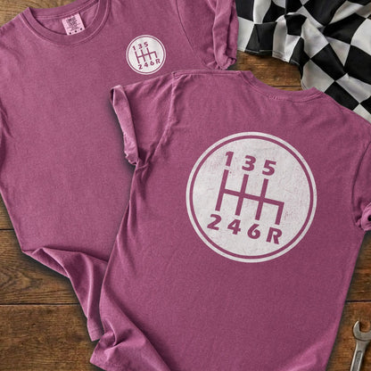 Maroon t-shirt with a white circular graphic of a six-speed manual transmission shift pattern.