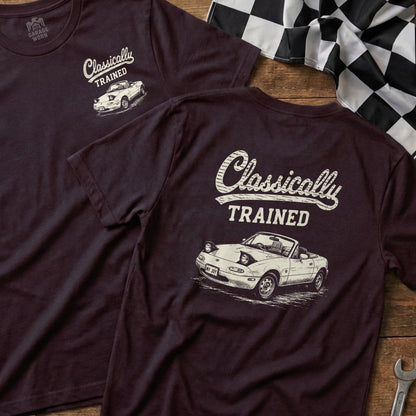 Dark shirts with cream graphic of a convertible sports car and text "Classically TRAINED."