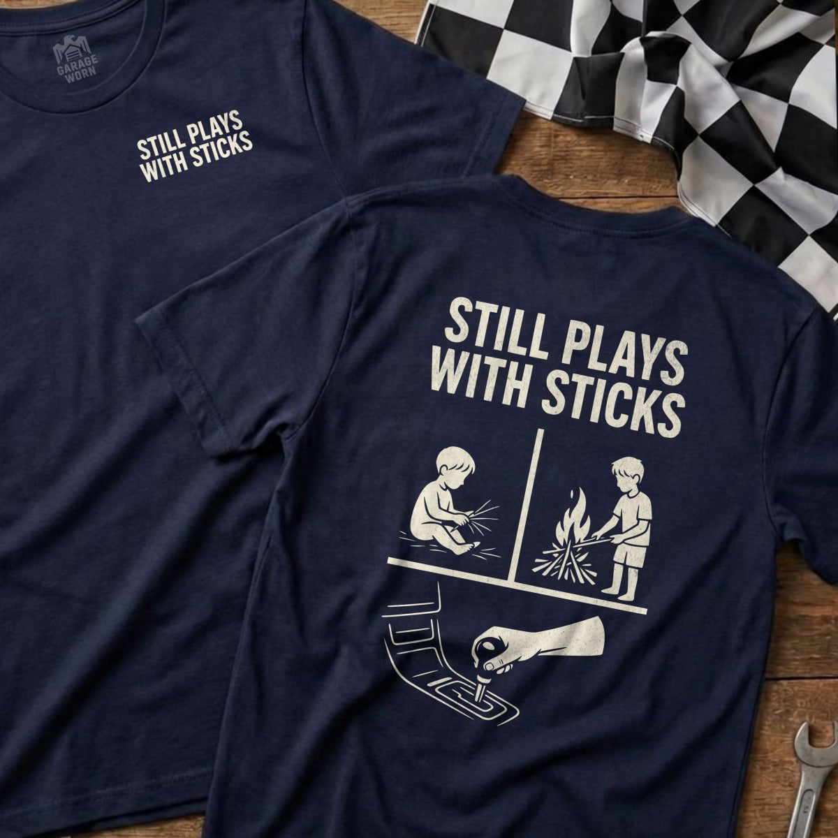 Navy t-shirt with "STILL PLAYS WITH STICKS" and cartoon figures.