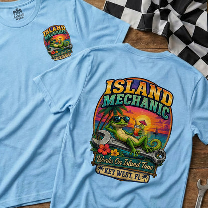 Light blue t-shirt with a graphic of a gecko on a wrench, drinking a cocktail.