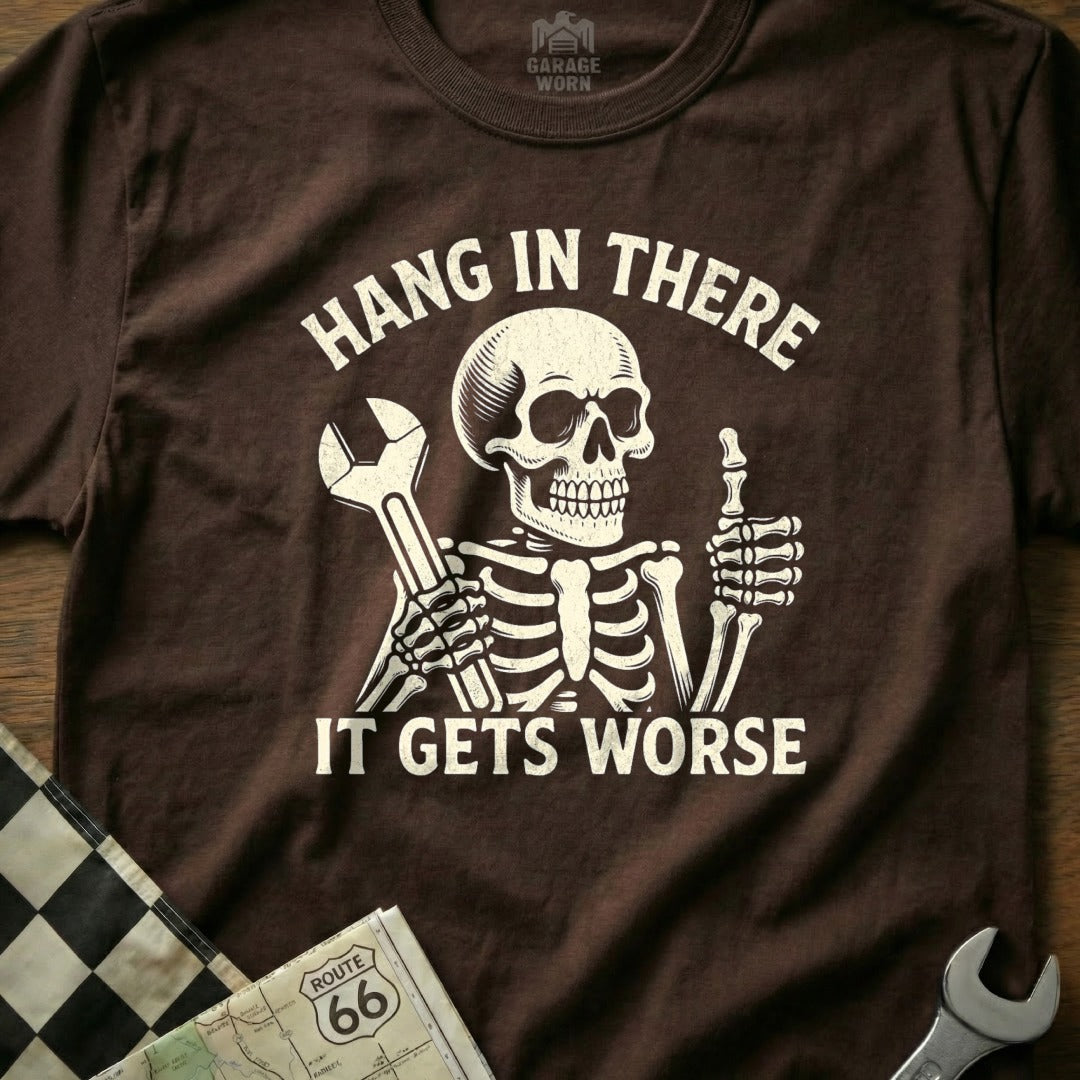 Skeleton wearing t-shirt with "Hang in there. It gets worse." text and wrench.