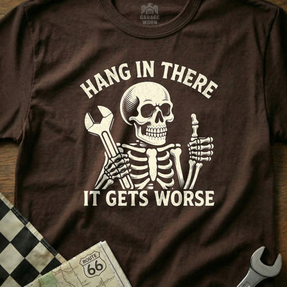 Skeleton wearing t-shirt with "Hang in there. It gets worse." text and wrench.