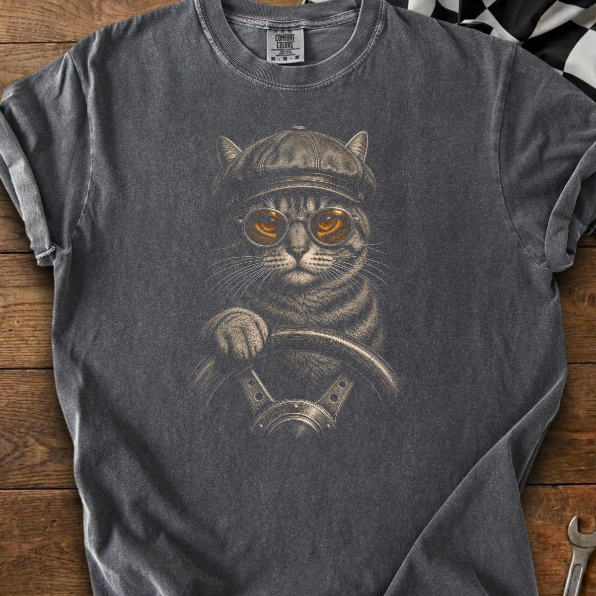 Gray t-shirt with graphic of cat wearing cap and goggles driving a car.