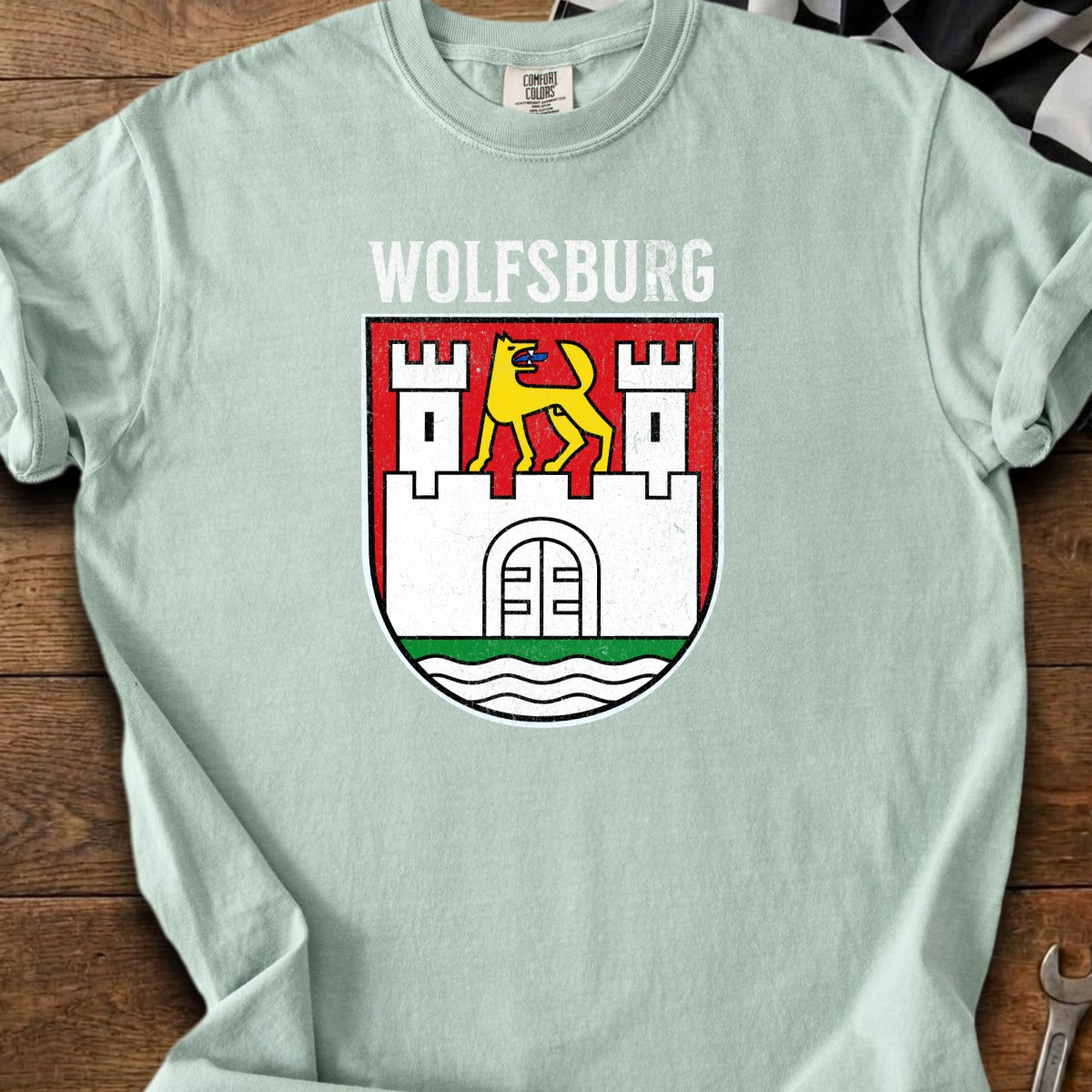 Light blue t-shirt with Wolfsburg crest featuring a castle and yellow wolf.