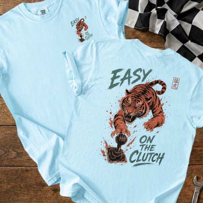 Light blue t-shirt with a graphic of a tiger and "EASY ON THE CLUTCH" text.