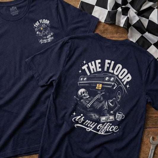 Navy t-shirt with "The Floor Is My Office" graphic featuring a skeleton working on a car.