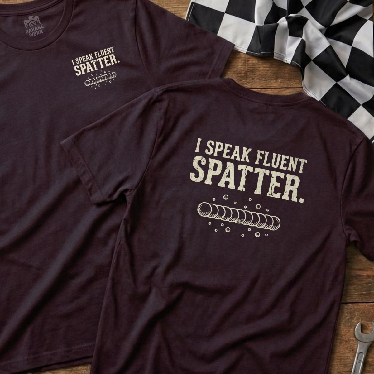 Burgundy t-shirt with "I SPEAK FLUENT SPATTER." text and welding bead graphic.
