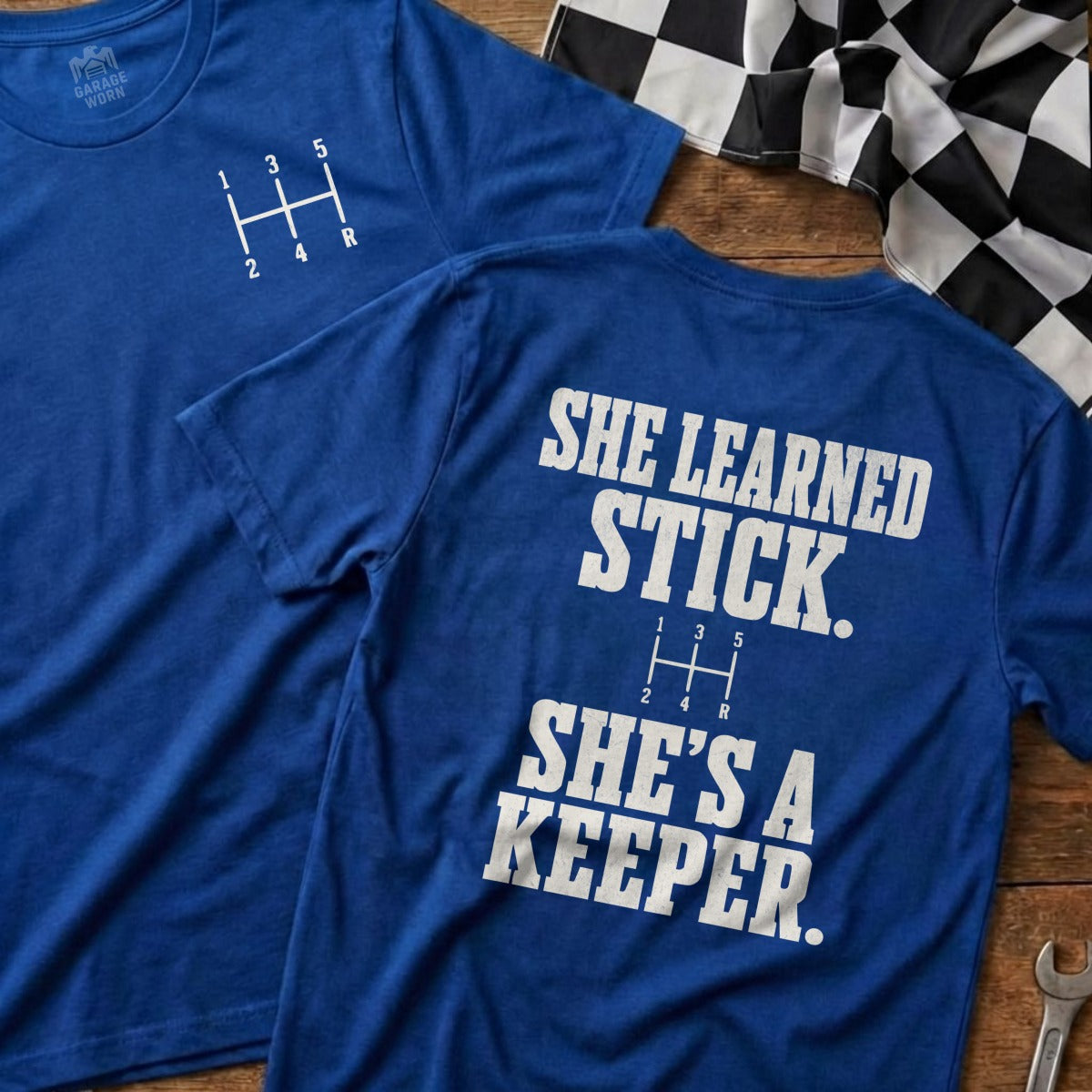 Blue t-shirt with manual gear shift pattern and "She learned stick. She's a keeper."