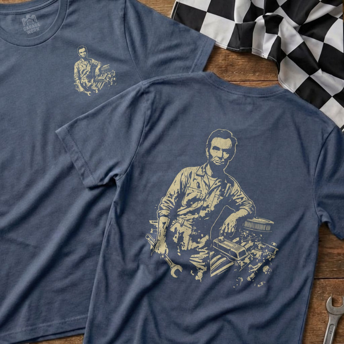 Abraham Lincoln leaning on a car engine, printed on a navy t-shirt.