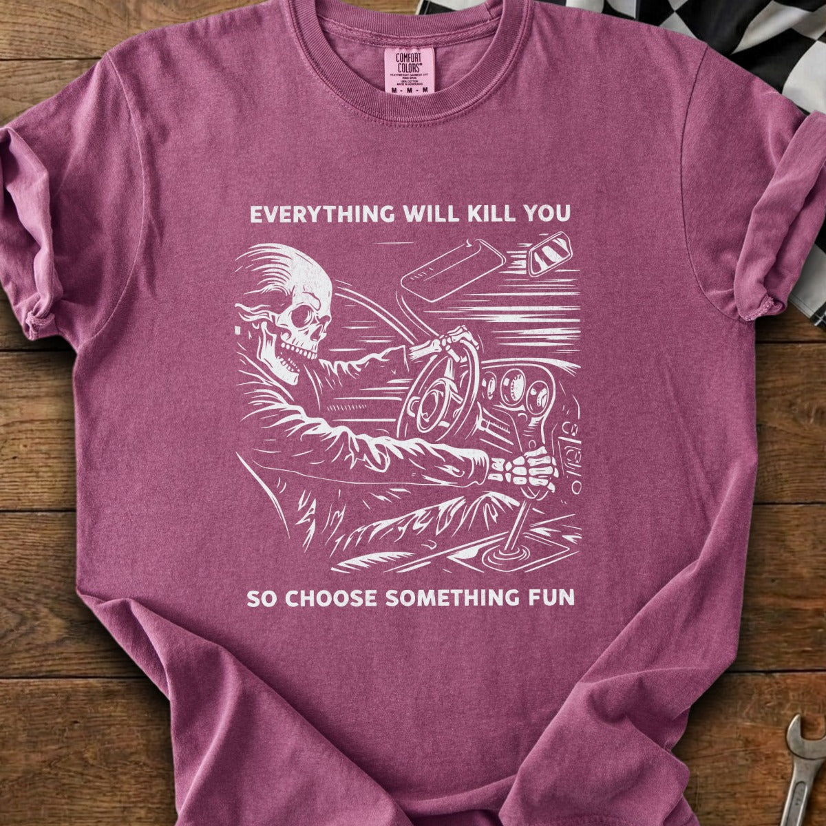T-shirt with skeleton driving, "Everything will kill you, so choose something fun."