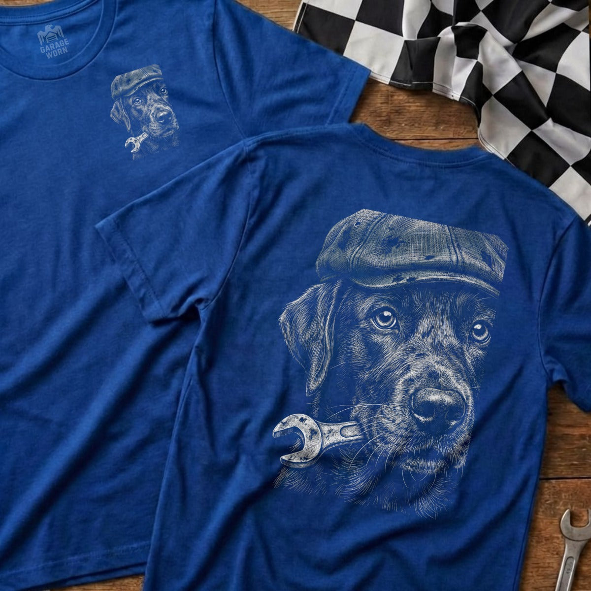 Blue t-shirt with a black lab wearing a cap and holding a wrench in its mouth.