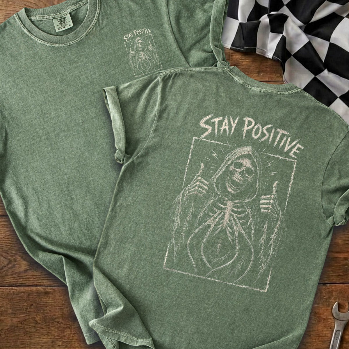 Green t-shirt with skeleton graphic and "STAY POSITIVE" text.
