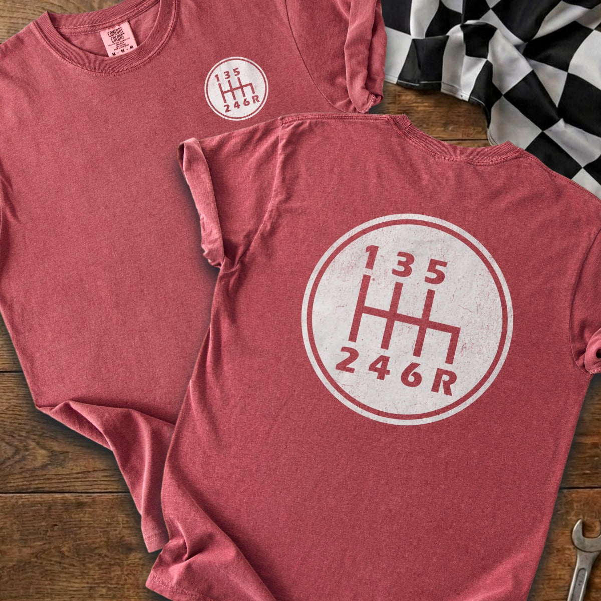 Two heather red t-shirts with a white 6-speed manual gear shift pattern graphic.