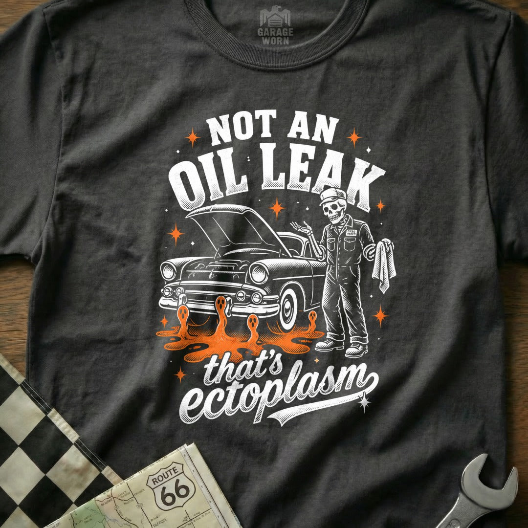 T-shirt graphic with skeleton mechanic, classic car, and "Not an oil leak that's ectoplasm" text.