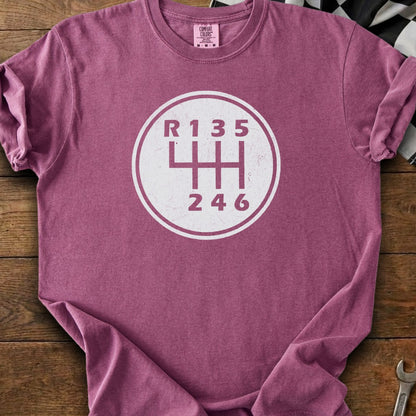 Maroon t-shirt with a white graphic of a manual transmission shift pattern showing R135 and 246.