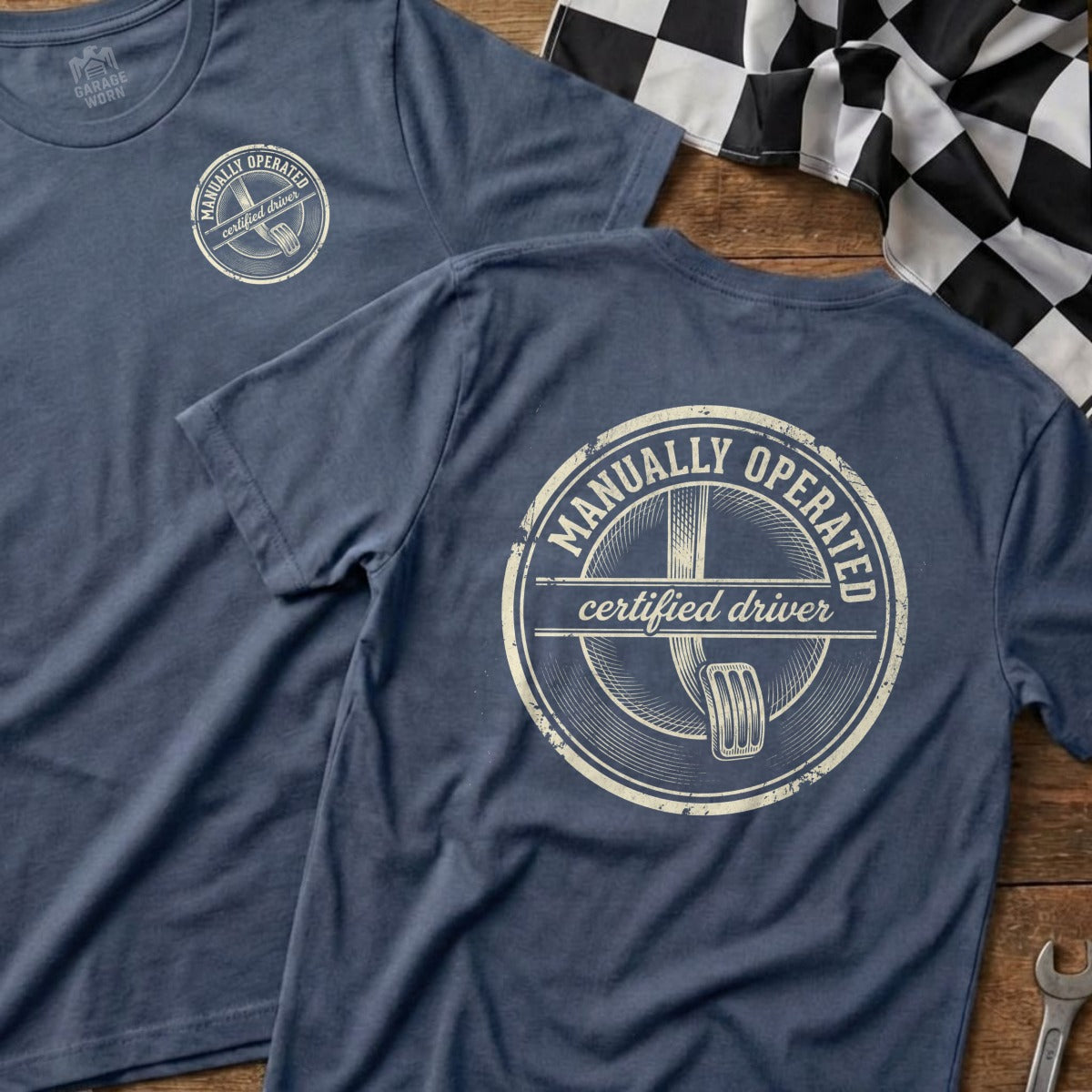Navy t-shirt with "Manually Operated Certified Driver" text and steering wheel graphic.
