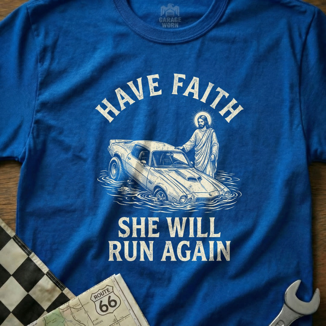 Blue t-shirt with Jesus helping a submerged car, text "HAVE FAITH SHE WILL RUN AGAIN".