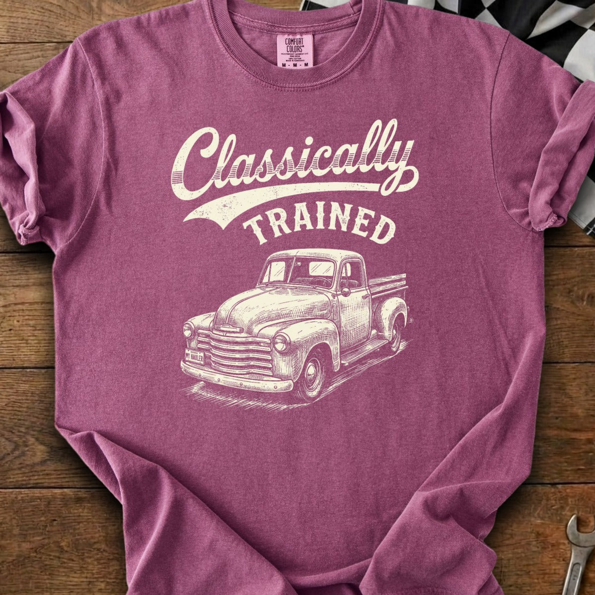 Berry colored t-shirt with white text "Classically TRAINED" and a drawing of a vintage truck.