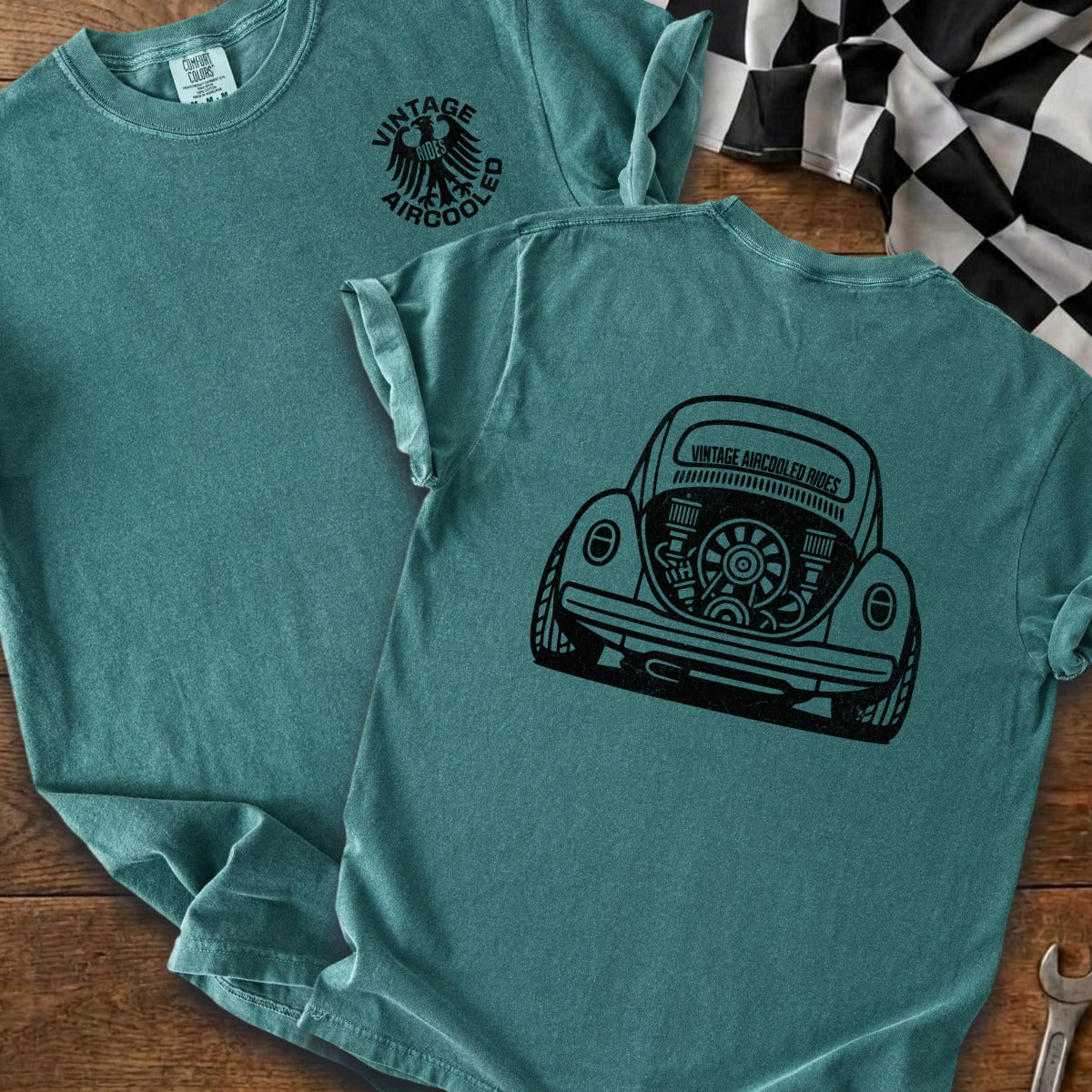 Teal t-shirt with black graphic of vintage air-cooled car engine on back.