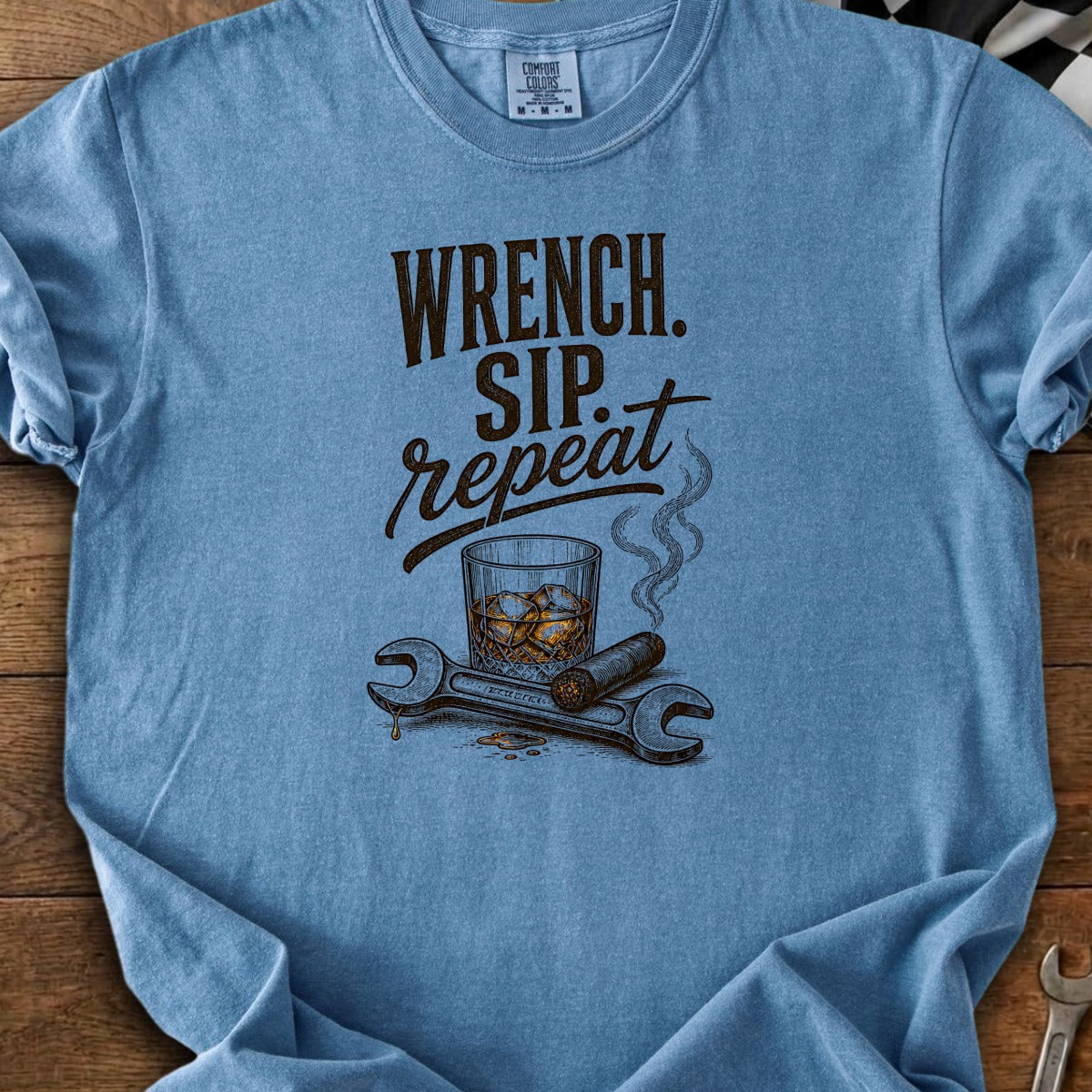 Blue t-shirt with "Wrench. Sip. Repeat." text, whiskey, cigar, and wrenches.